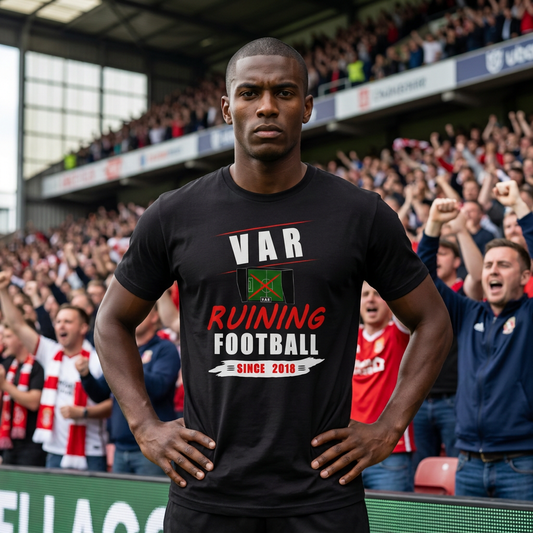 Fan standing hands on hips in a cheering stadium crowd wearing the black VAR Ruining Football Since 2018 t-shirt