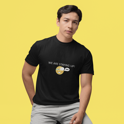 Man wearing a black short sleeve T-shirt with a round neck and the wording we are staying up with a phew emoji on a yellow studio background