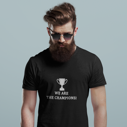 Man wearing a black t-shirt with 'We Are The Champions!' text and graphic of a trophy on a grey background